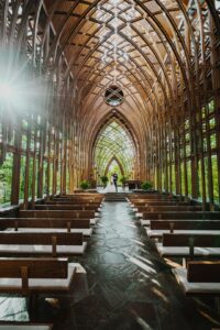 Bride and groom standing at a church altar with guests seated in wooden pews.