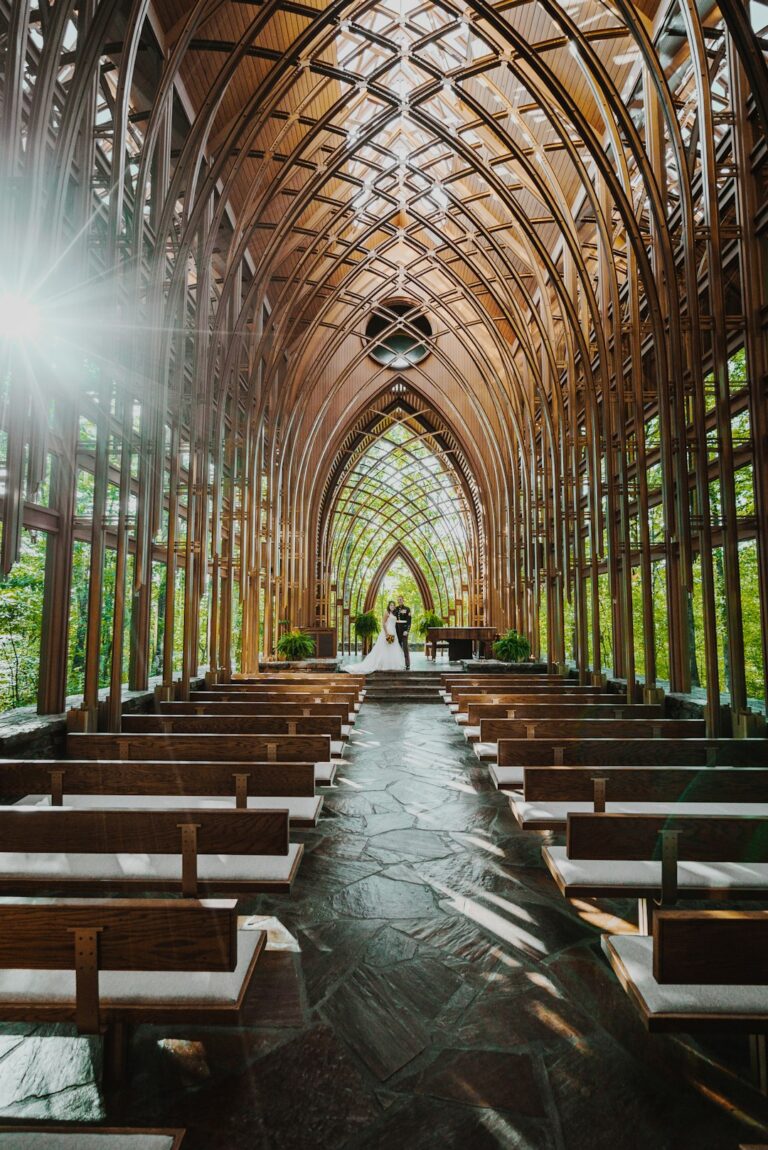 Bride and groom standing at a church altar with guests seated in wooden pews.